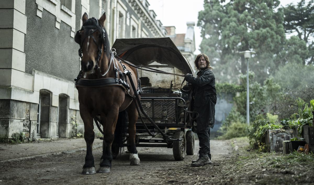 Daryl (Norman Reedus) stands beside a horse and carriage in The Walking Dead: Daryl Dixon